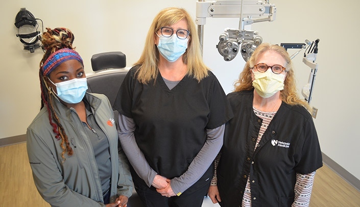 Image with caption: From left, technician Alison Erickson, clinic director Karen Wilson, OD, and optician Lori Cervantes at the Munroe-Meyer Institute's Caring for Champions Program Vision Clinic.